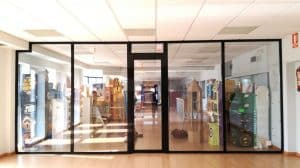 Escaparate y puerta de entrada de aluminio negro en un local comercial