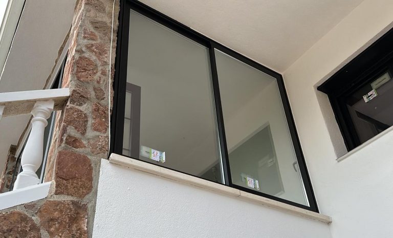 Ventana corredera de aluminio negro instalada en una vivienda