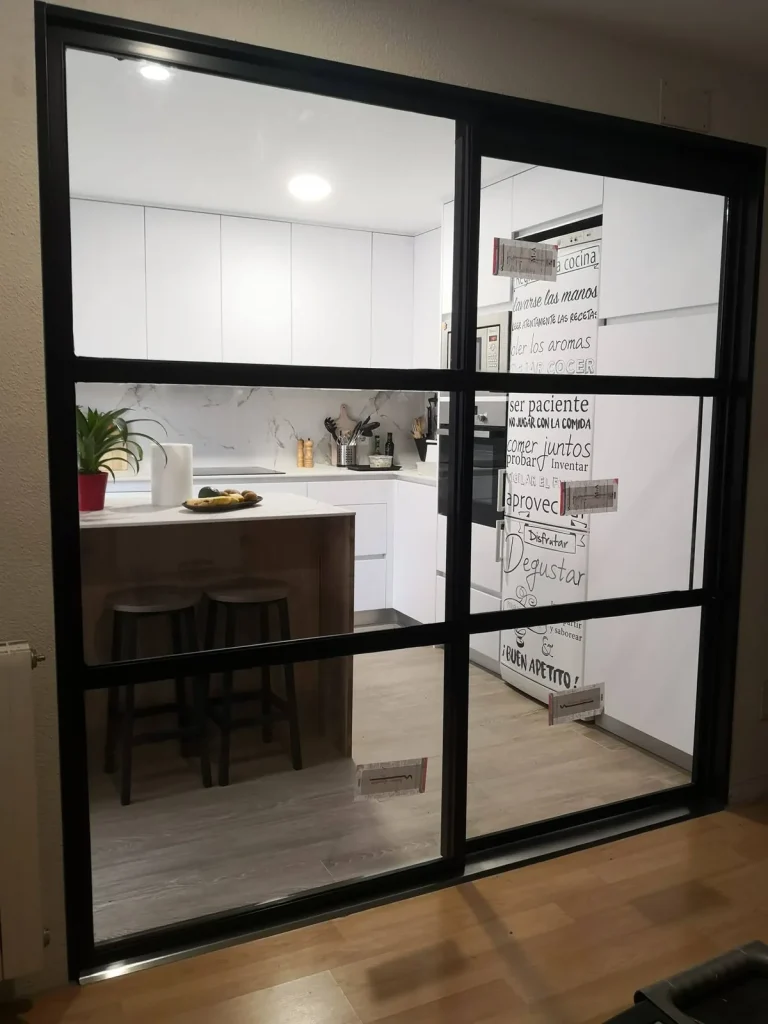 Cerramiento de cocina de aluminio negro con correderas de vidrio y travesaños, estilo industrial